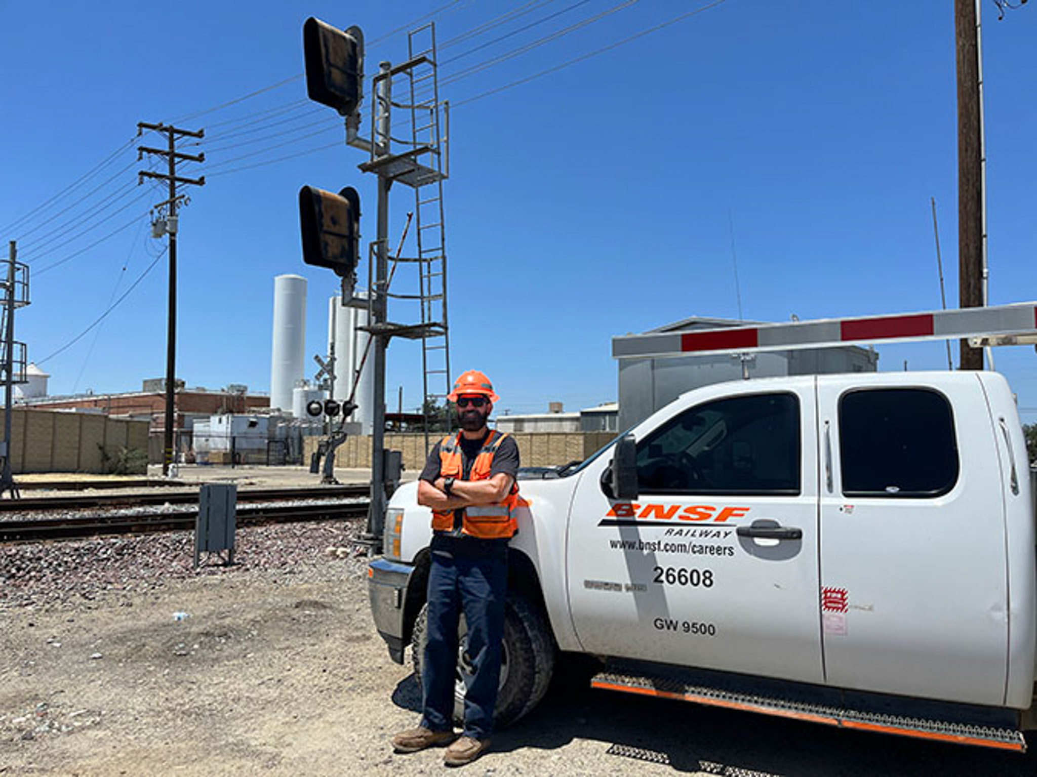Chavez in front of a BNSF truck with train signals in the background